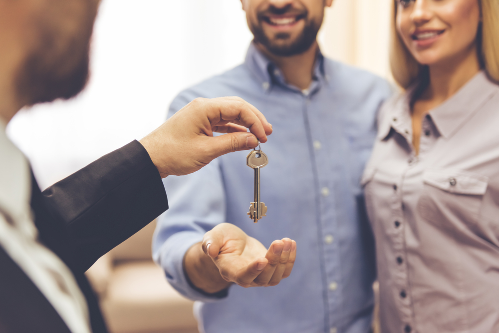Property manager handing couple set of keys